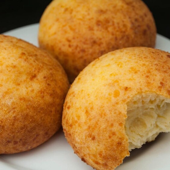 Three round, golden-brown fried dough balls on a white plate. 2