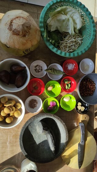 A variety of food items and cooking utensils on a wooden table. 1