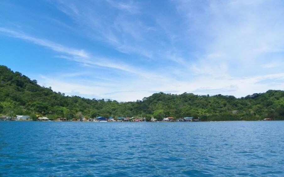 A calm lake with a forested hillside in the background. 3
