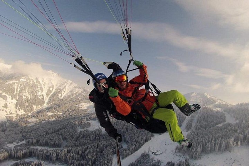 To personer paraglider over et snøklædt bjerglandskab. 4