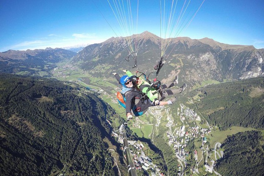En paraglider svæver hen over et bjergrigt landskab med en dal nedenfor. 5