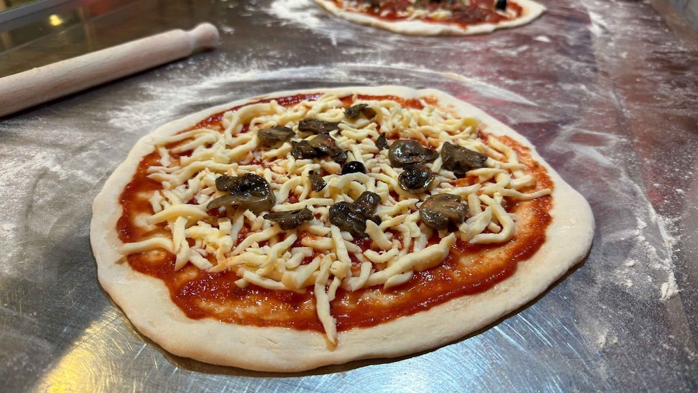 A pizza with cheese and mushrooms on a metal surface. 3