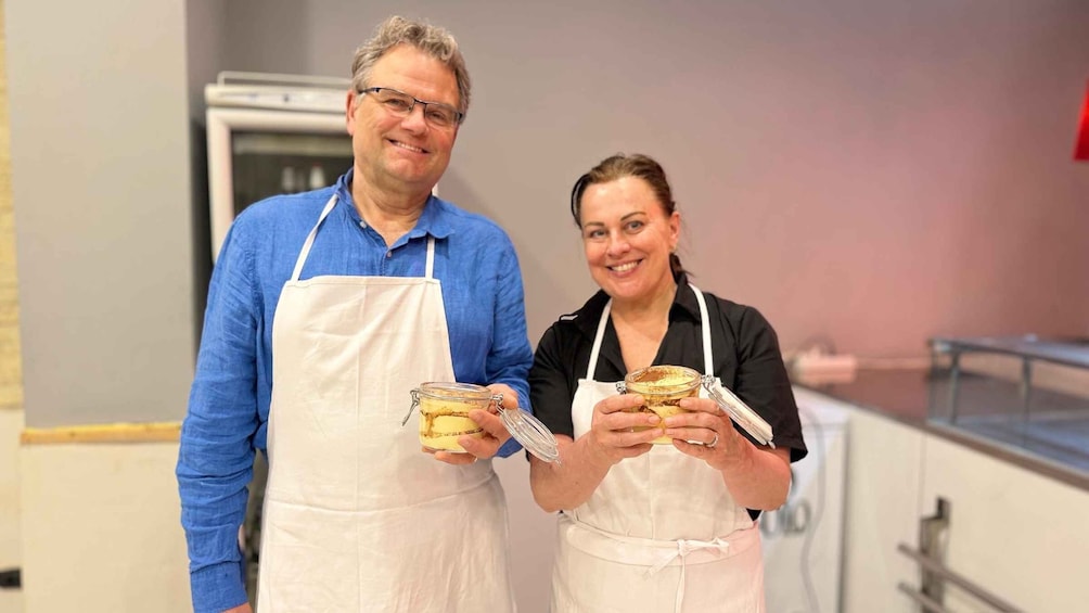 Two people in a kitchen holding jars of food. 4
