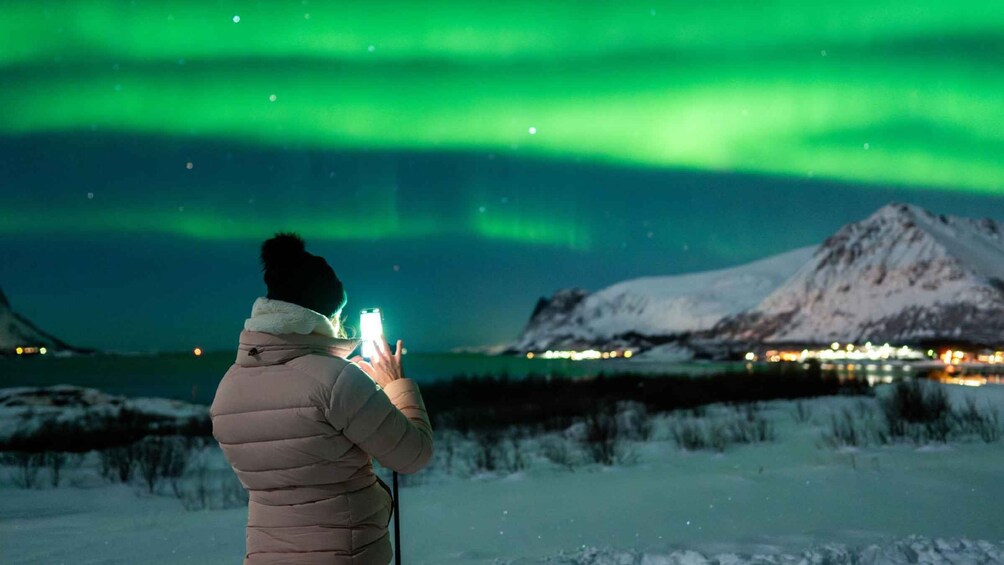 En person tager et billede af nordlyset med en smartphone. 2