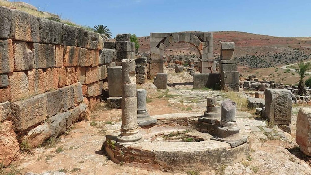 Ancient ruins with stone columns and a partially intact archway. 3