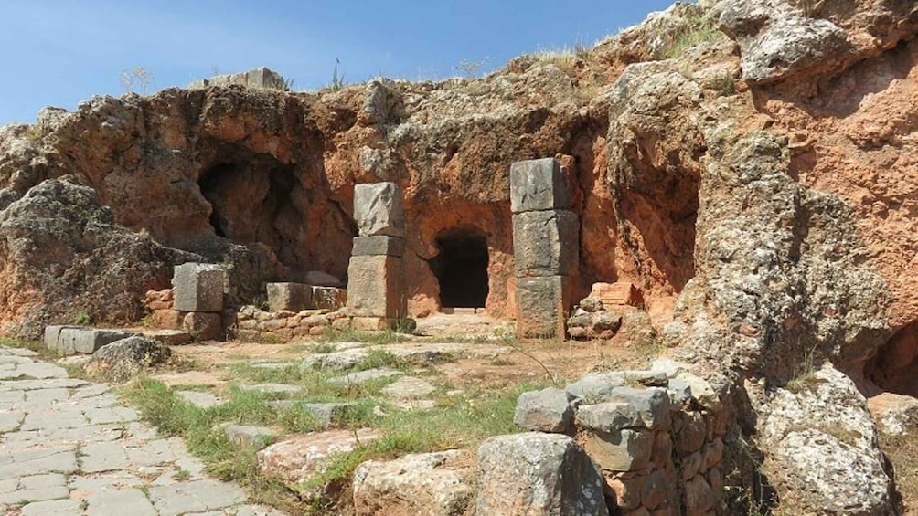 Ancient ruins with stone structures and a cave-like entrance. 5