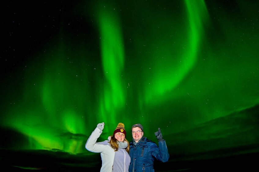 Two people posing under the Northern Lights. 5