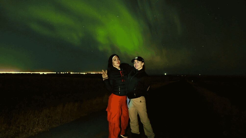 Two people posing under the aurora borealis. 3