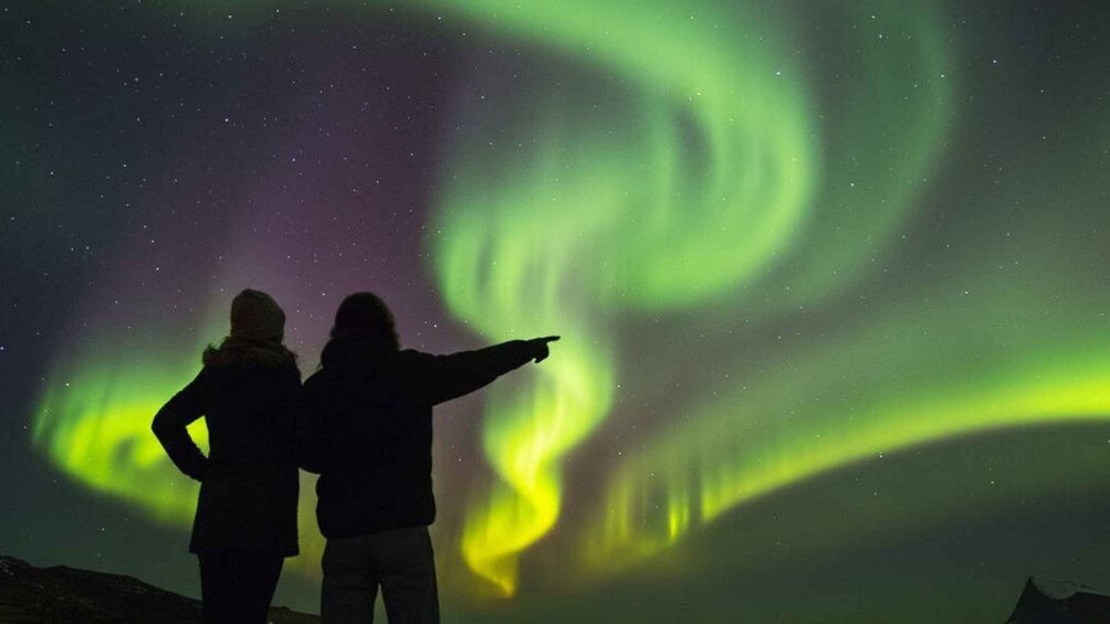 Two people observing the Northern Lights. 1