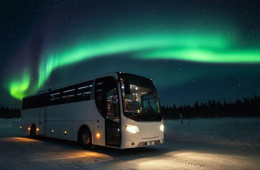 A bus parked on a snowy road under a night sky with the aurora borealis. 4