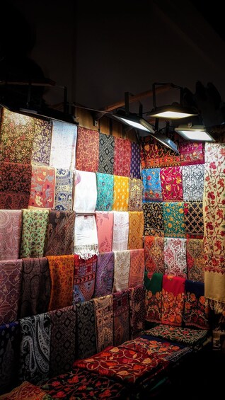 A wall of colorful fabrics displayed in a shop. 4