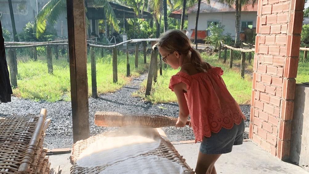 A person pouring water from a woven basket into a brick structure. 3