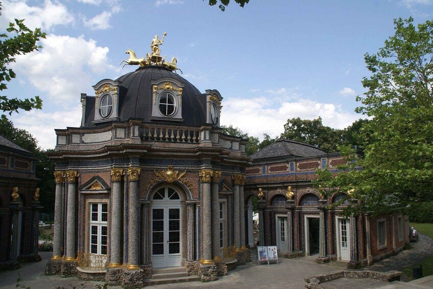 A historic building with a dome, columns, and a statue on top. 4