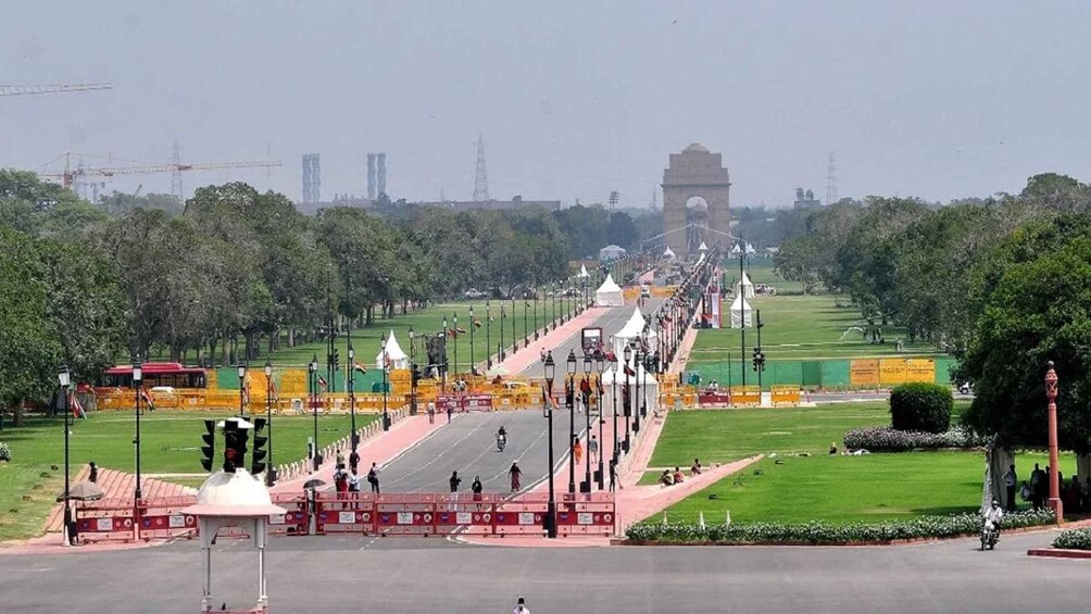 A wide avenue leading to a prominent archway, with trees and open spaces on either side. 5