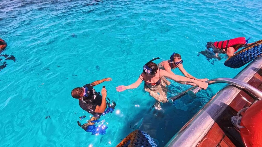 A group of people snorkeling in clear blue water. 3