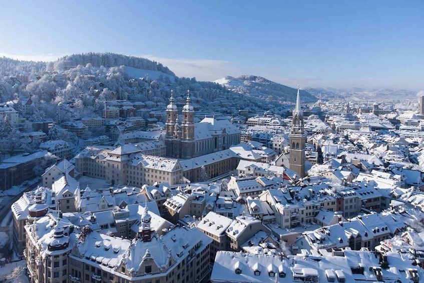 A snow-covered cityscape with prominent historical buildings and a church spire. 1