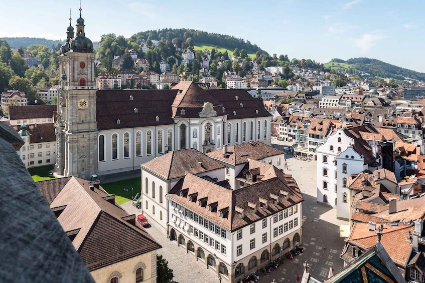 A historic town with a prominent church, a clock tower, and a hill in the background. 4