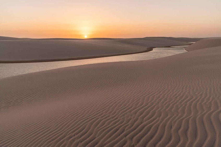 Sand dunes, a water body, and a sunset. 2