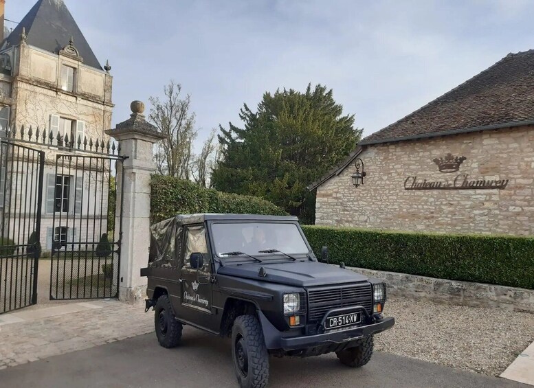 A black off-road vehicle parked in front of a stone building with a sign reading 'Chateau de Chamvery.' 5