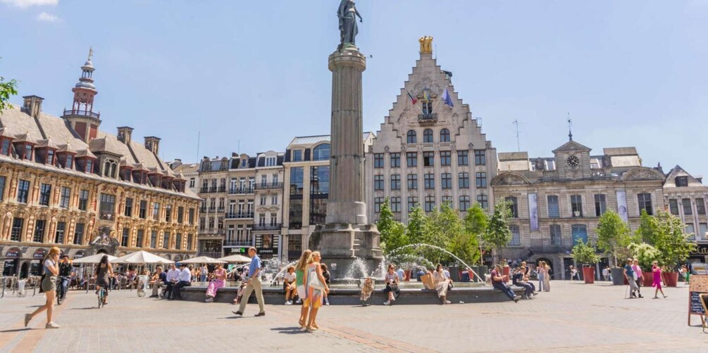 A bustling square with a central fountain, historic buildings, and a statue. 1