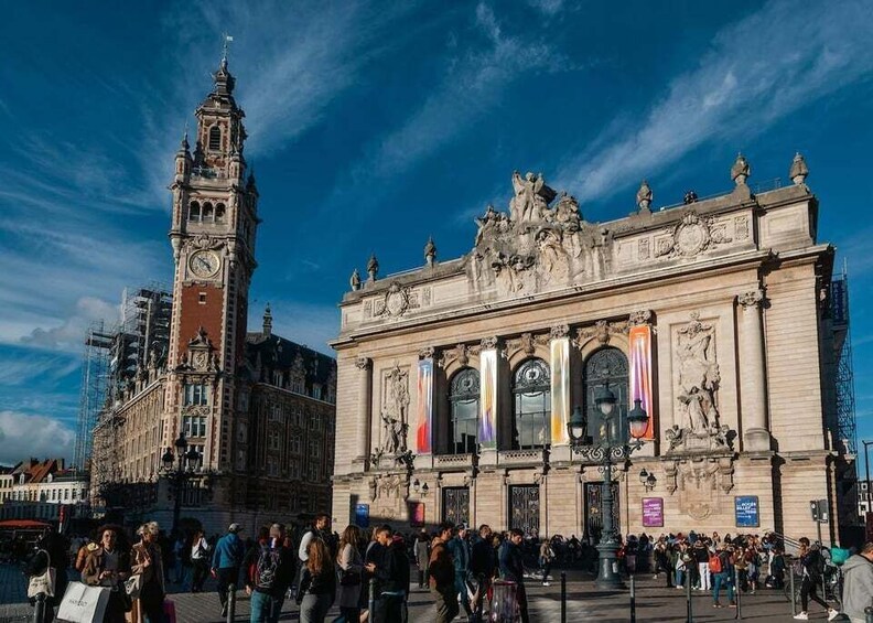 A historic building with a clock tower, a busy square, and a clear blue sky. 5