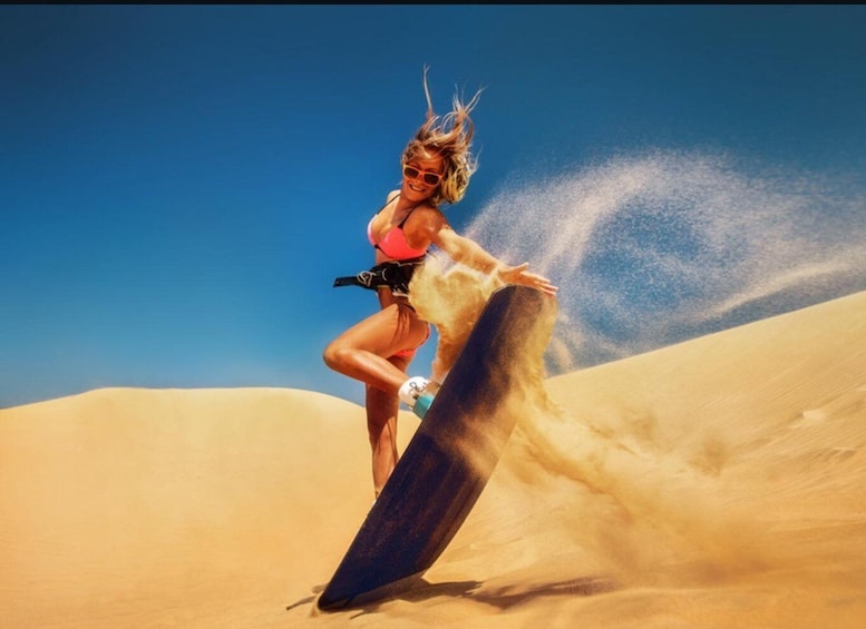 A person surfing on a sand dune. 3