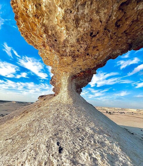 A rock formation with a hole in the center, surrounded by a barren landscape. 2