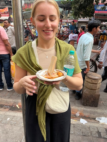A person holding a plate with food and a bottle of water. 1
