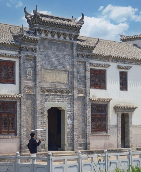 A traditional Chinese building with ornate roof tiles and detailed wooden lattice windows. 4