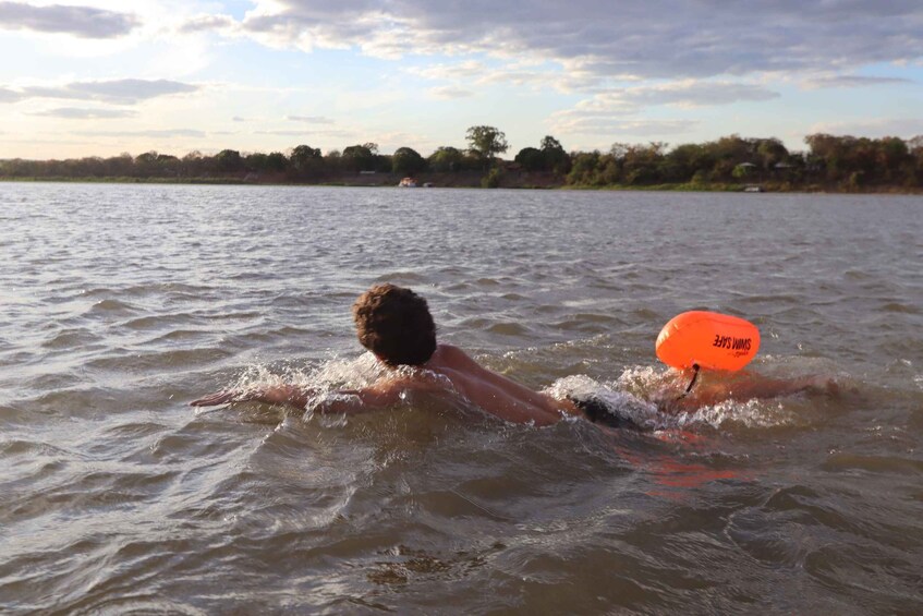A person swimming in a body of water with a floating object. 4