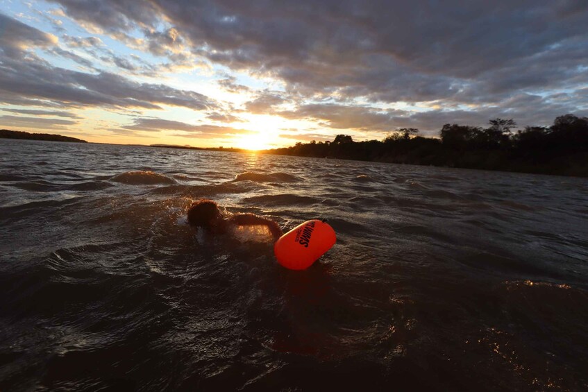 A body of water with a floating object and a sunset in the background. 5
