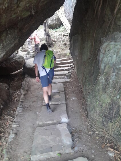 A person walking on a stone staircase in a rocky area. 1
