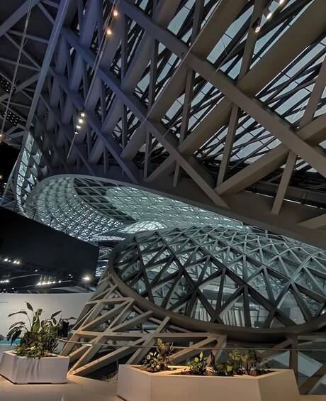 A modern architectural structure with a geometric glass roof and steel framework. 5