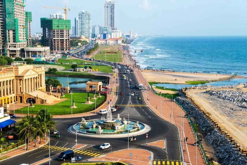 A coastal cityscape with a roundabout, a beach, and high-rise buildings. 5