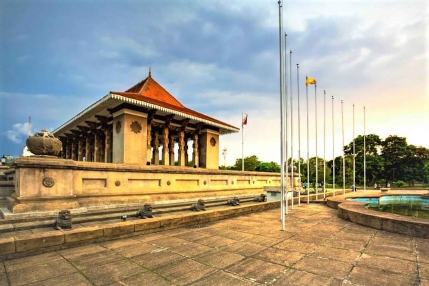 A traditional building with a red roof, surrounded by a stone plaza and flagpoles. 3
