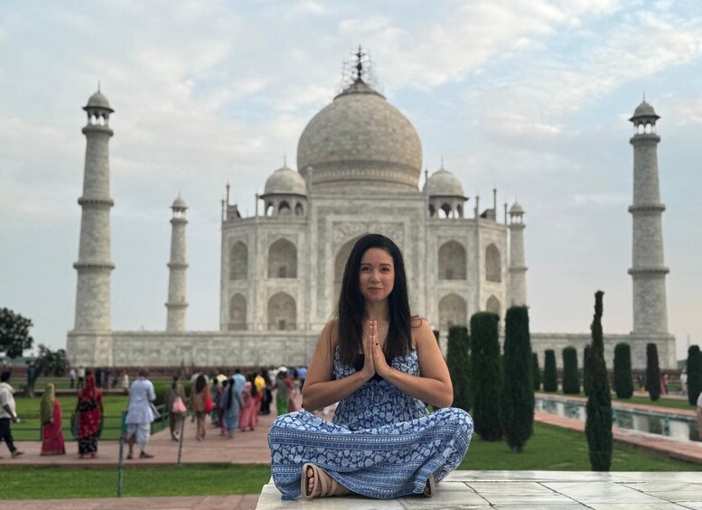A person sitting in a meditative pose with the Taj Mahal in the background. 2