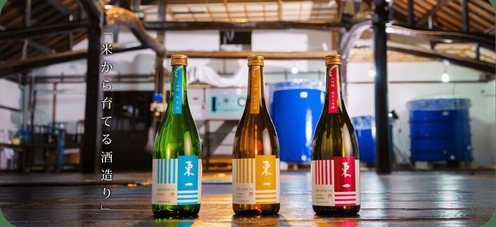 Three bottles of sake on a wooden surface in a warehouse. 5