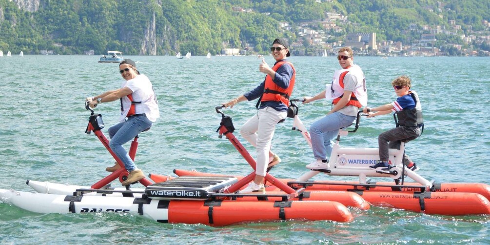 People riding water bikes on a lake with boats in the background. 5