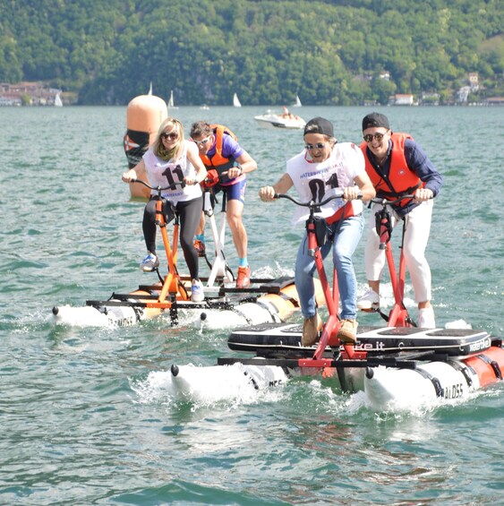 People riding water bikes on a lake with boats in the background. 3