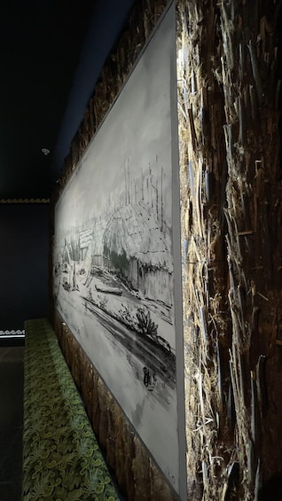 A wall with a monochrome painting of a rural scene, including a thatched-roof house and a river. 4