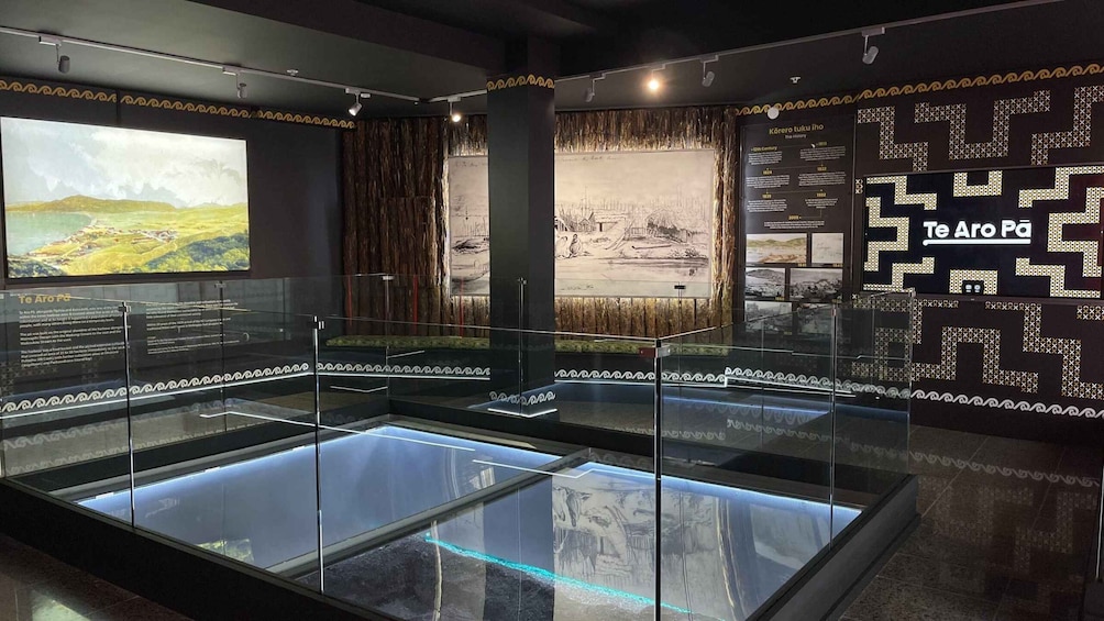 An indoor exhibit with glass display cases, historical timelines, and decorative wall patterns. 5