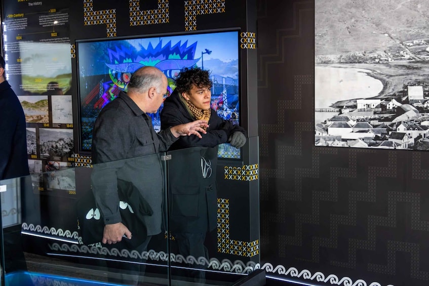 A museum exhibit with historical photographs and a digital display. 1