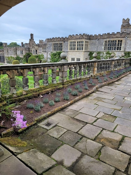 A stone pathway leading to a historic building with a garden in the foreground. 3