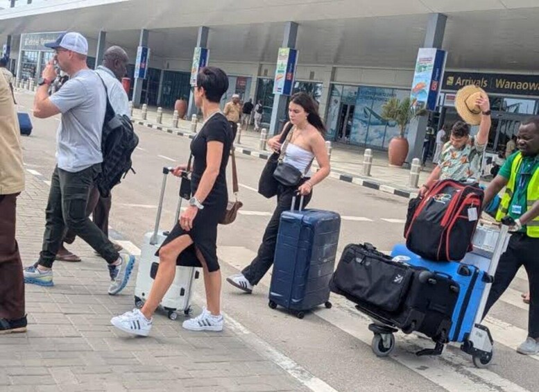 A group of people walking with luggage at an airport. 3