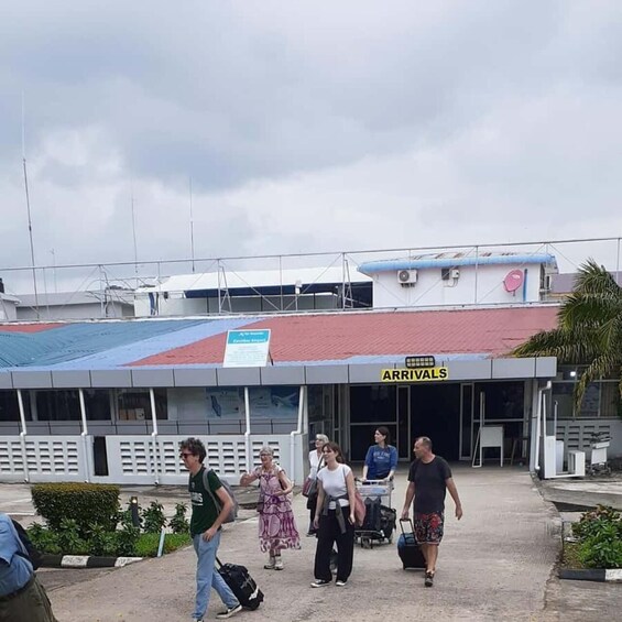 A building with a sign reading 'ARRIVALS' and people walking towards it. 4