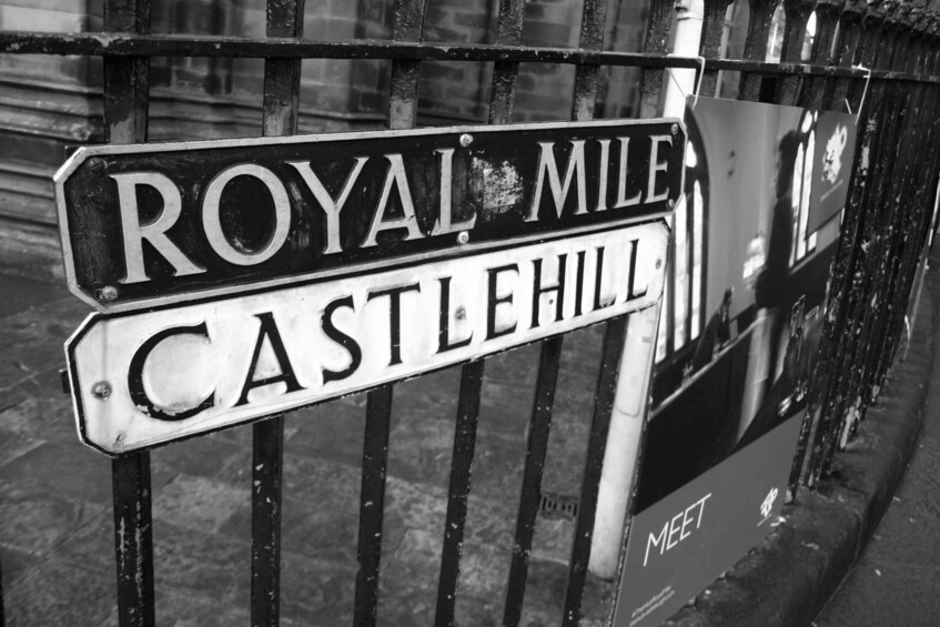 A black and white street sign with 'ROYAL MILE' and 'CASTLEHILL' written on it. 1