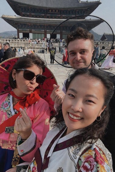 A traditional Korean building with a curved roof and a crowd of people in the background. 5