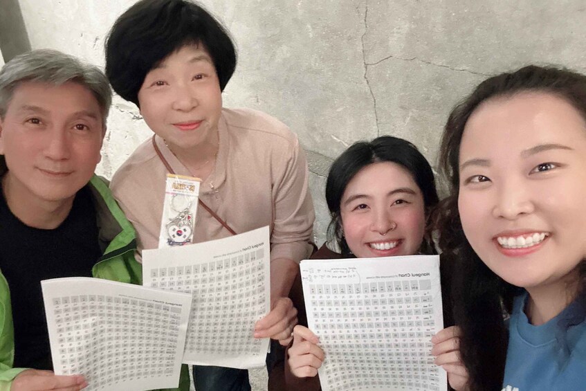 Four people holding papers with printed grids. 2