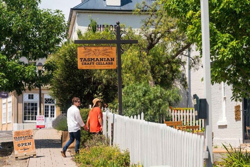Tasmanian craft cellars with a white picket fence and greenery. 5