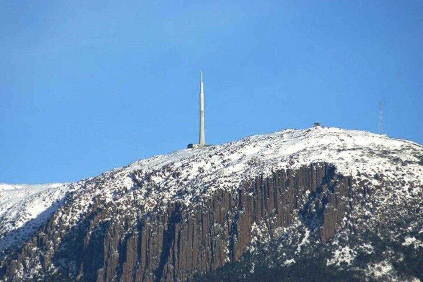 A snow-covered mountain with a tall, thin tower on top. 3
